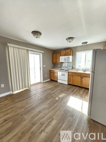 A kitchen with wooden floors and white appliances.