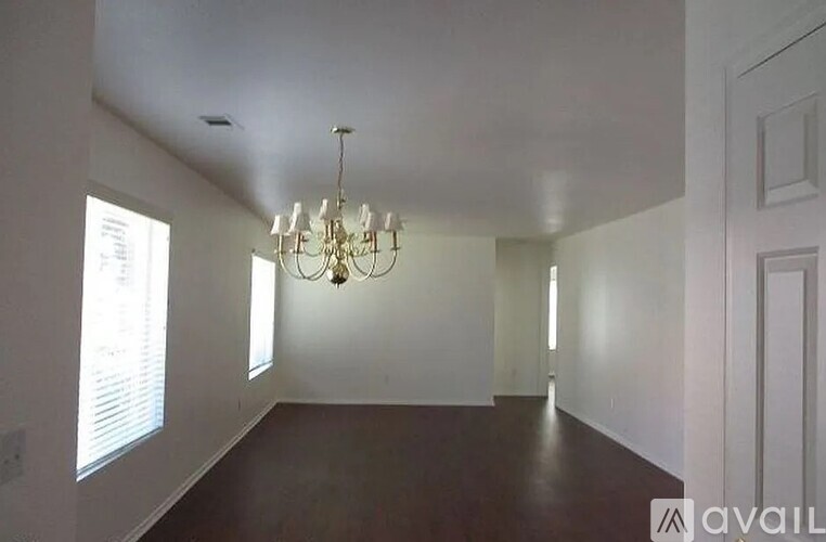 A large empty room with a chandelier hanging from the ceiling.