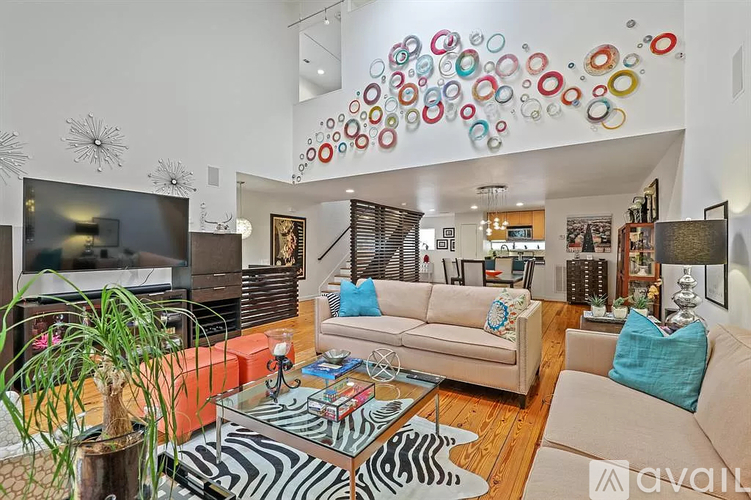 A living room with a zebra print rug and a glass coffee table.