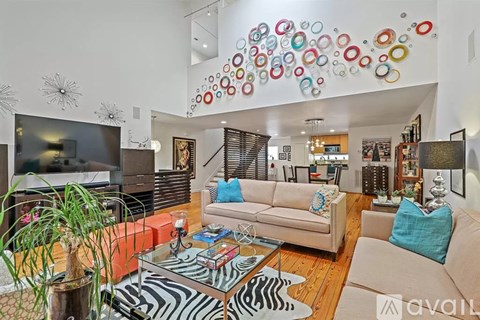 A living room with a zebra print rug and a glass coffee table.