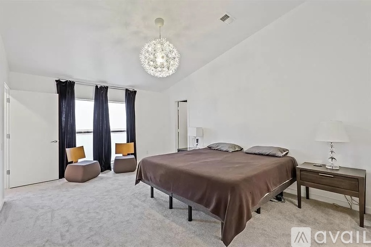 A bedroom with a large bed and a chandelier.