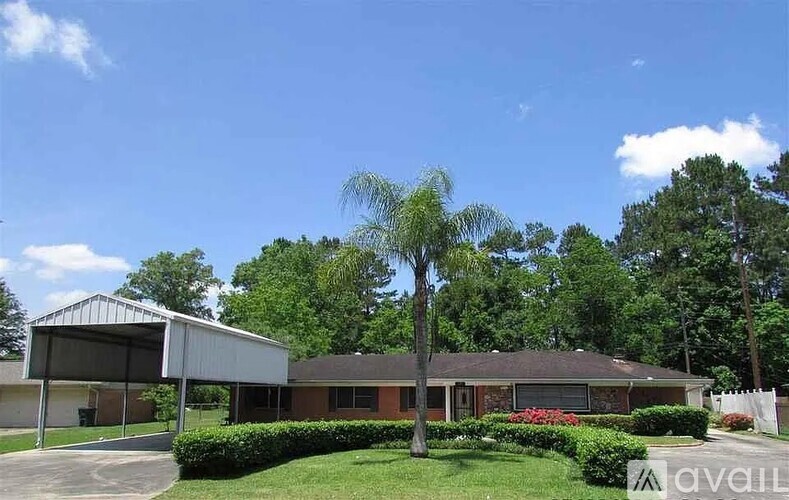 A house with a driveway and trees in the background.