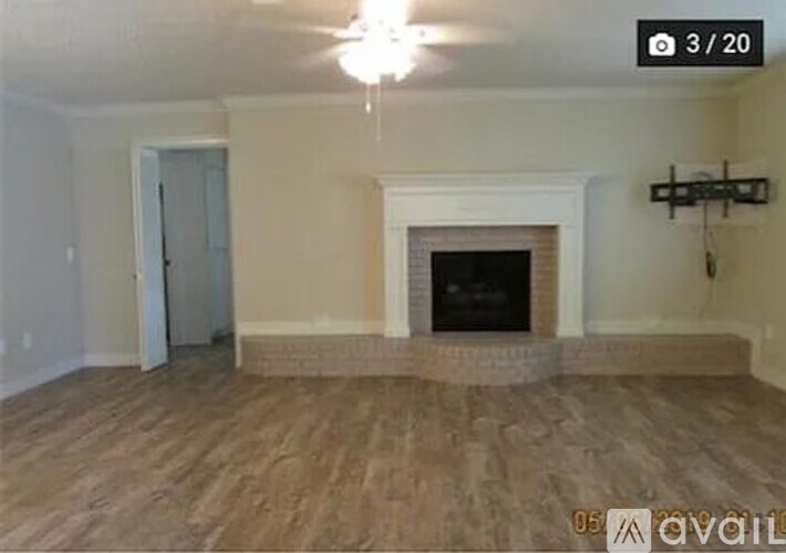 A living room with a fireplace and wood flooring.