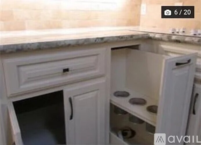 A kitchen with a white oven and cabinets.