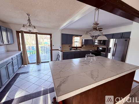 A kitchen with a marble countertop and a ceiling fan.