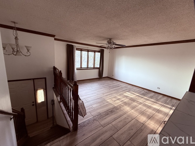 A room with wooden floors and a ceiling fan.