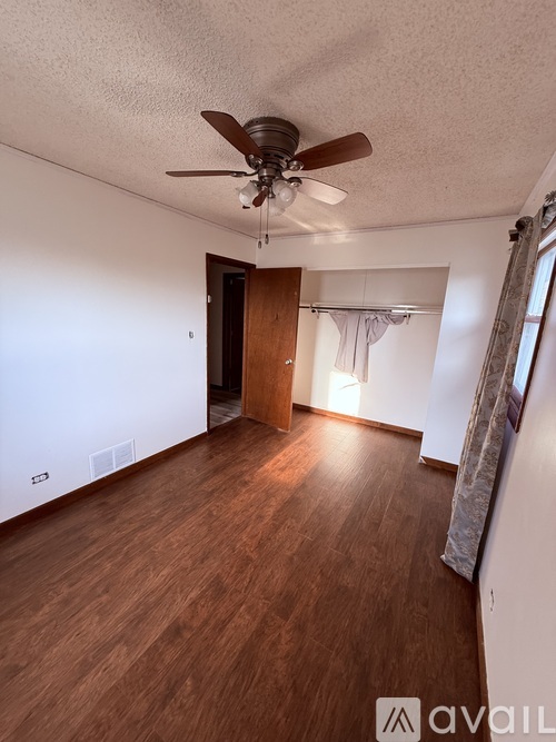 A room with wooden floors and a ceiling fan.