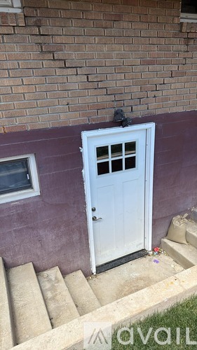 A white door with a window above it and steps leading up to it.