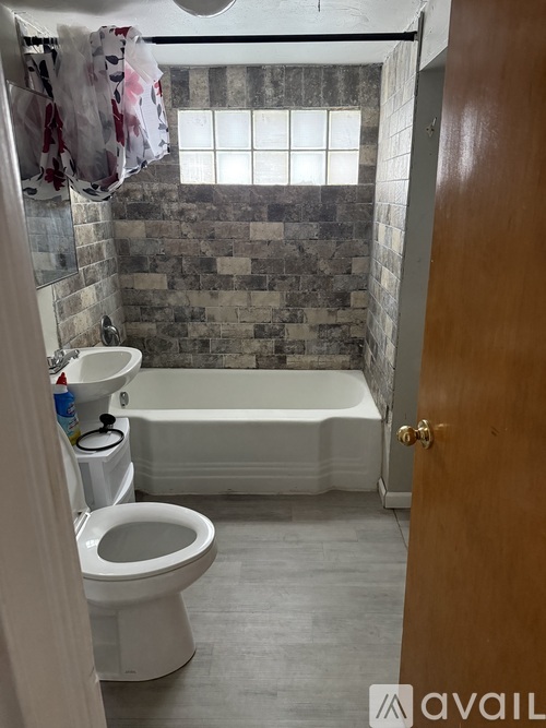 A bathroom with a toilet, sink, and tub.