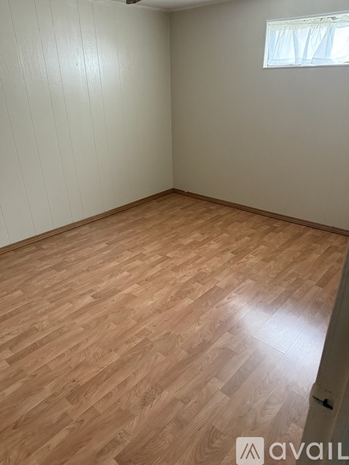 A room with wooden flooring and a window.