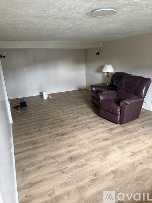 A room with a purple leather chair and wooden flooring.