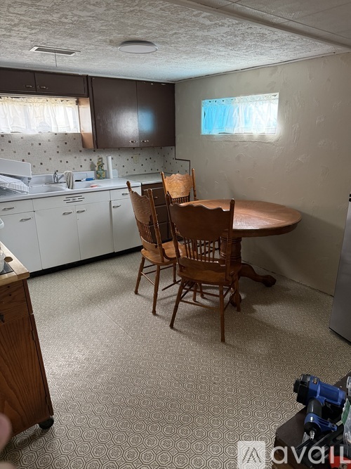 A kitchen with a table and chairs in the middle of the room.