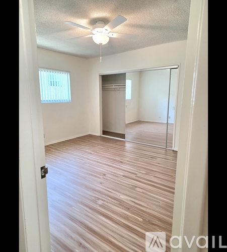 A room with wooden flooring and a ceiling fan.