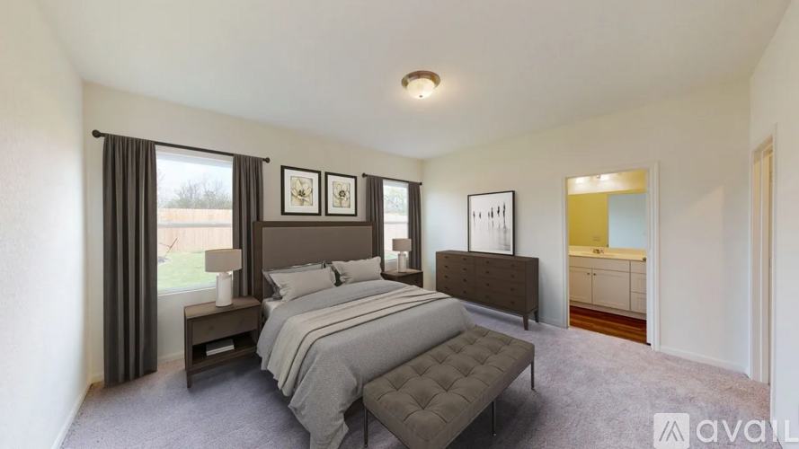 A bedroom with a large bed and a bench in front of it.