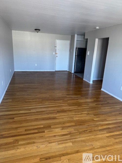 A room with wooden flooring and white walls.