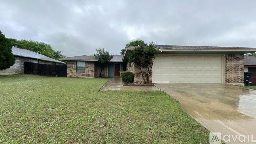 A house with a garage and a driveway in front of it.