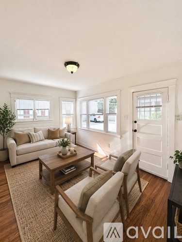 A living room with a couch, chairs, and a coffee table.