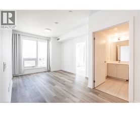 A spacious room with a wooden floor and a large mirror on the wall.