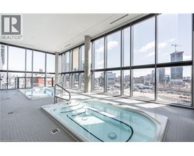 A large indoor swimming pool with a glass wall overlooking a cityscape.