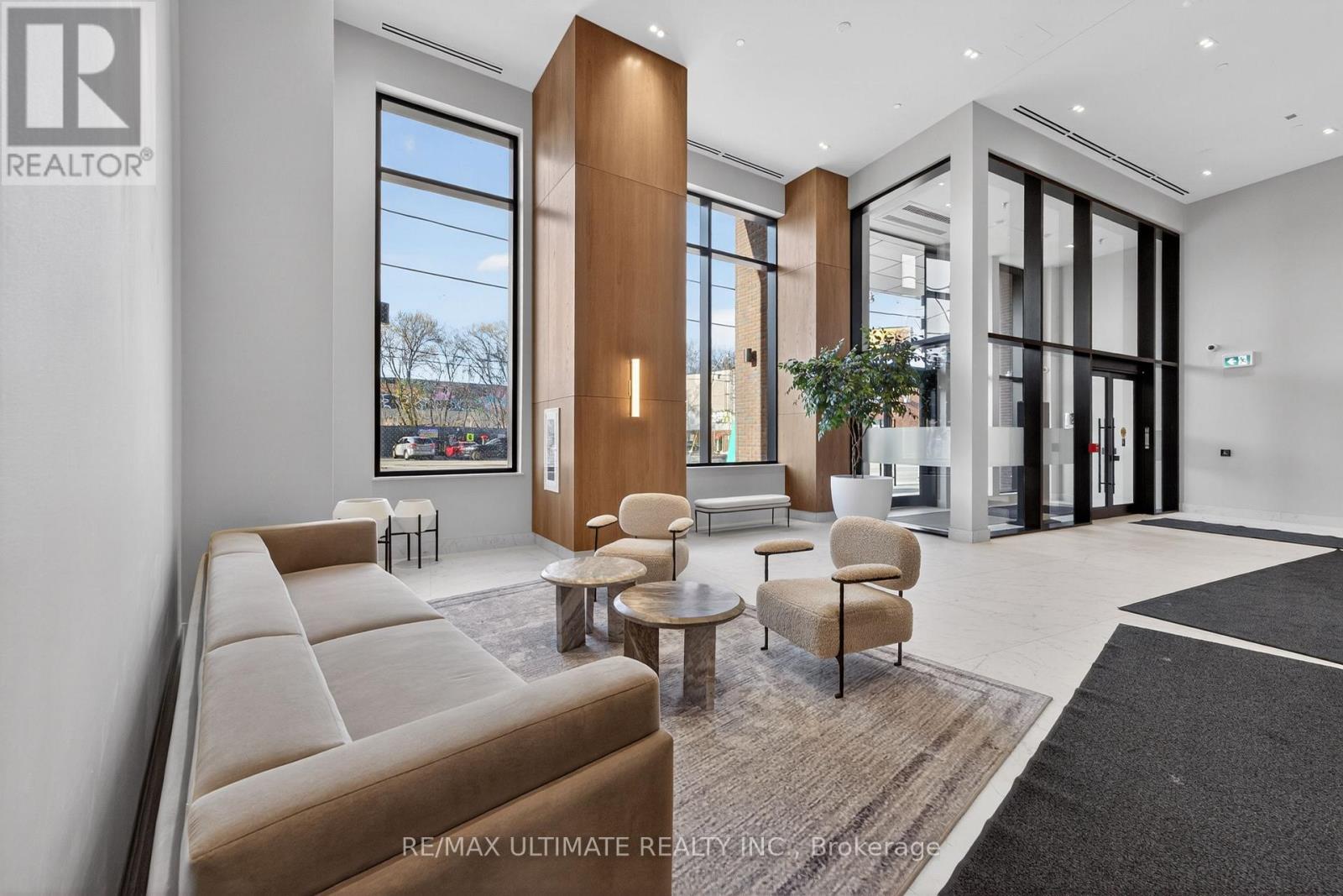 A modern living room with a large window and a view of trees outside.