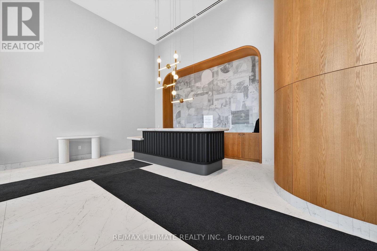 A modern office space with a wooden reception desk and a chandelier.