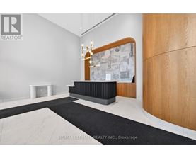 A modern office space with a wooden reception desk and a chandelier.