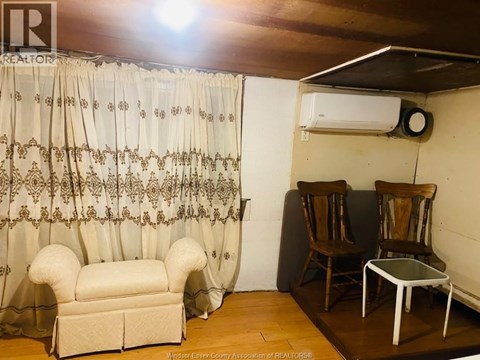 A living room with a sofa, chairs, and a curtain.