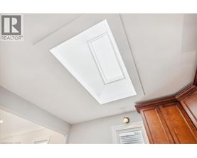 A white ceiling with a light fixture and a wooden cabinet.