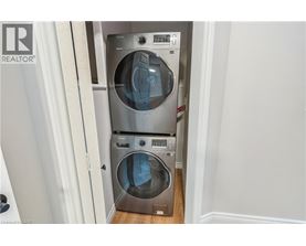 A washer and dryer stacked on top of each other in a small laundry room.
