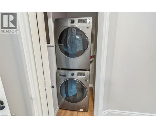 A washer and dryer stacked on top of each other in a small laundry room.