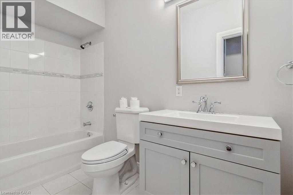 A white bathroom with a toilet, sink and bathtub.