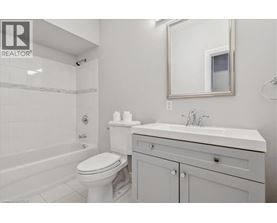 A white bathroom with a toilet, sink and bathtub.