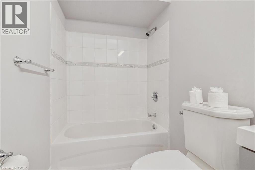 A white bathroom with a tub, toilet, and sink.