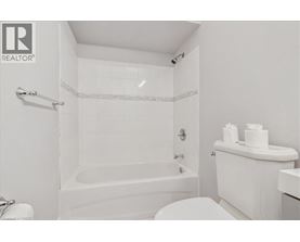 A white bathroom with a tub, toilet, and sink.