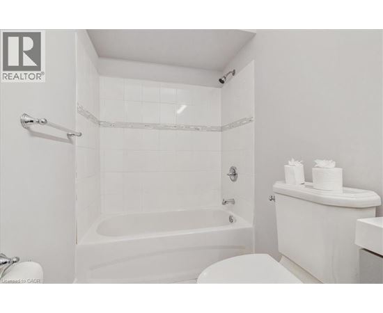 A white bathroom with a tub, toilet, and sink.