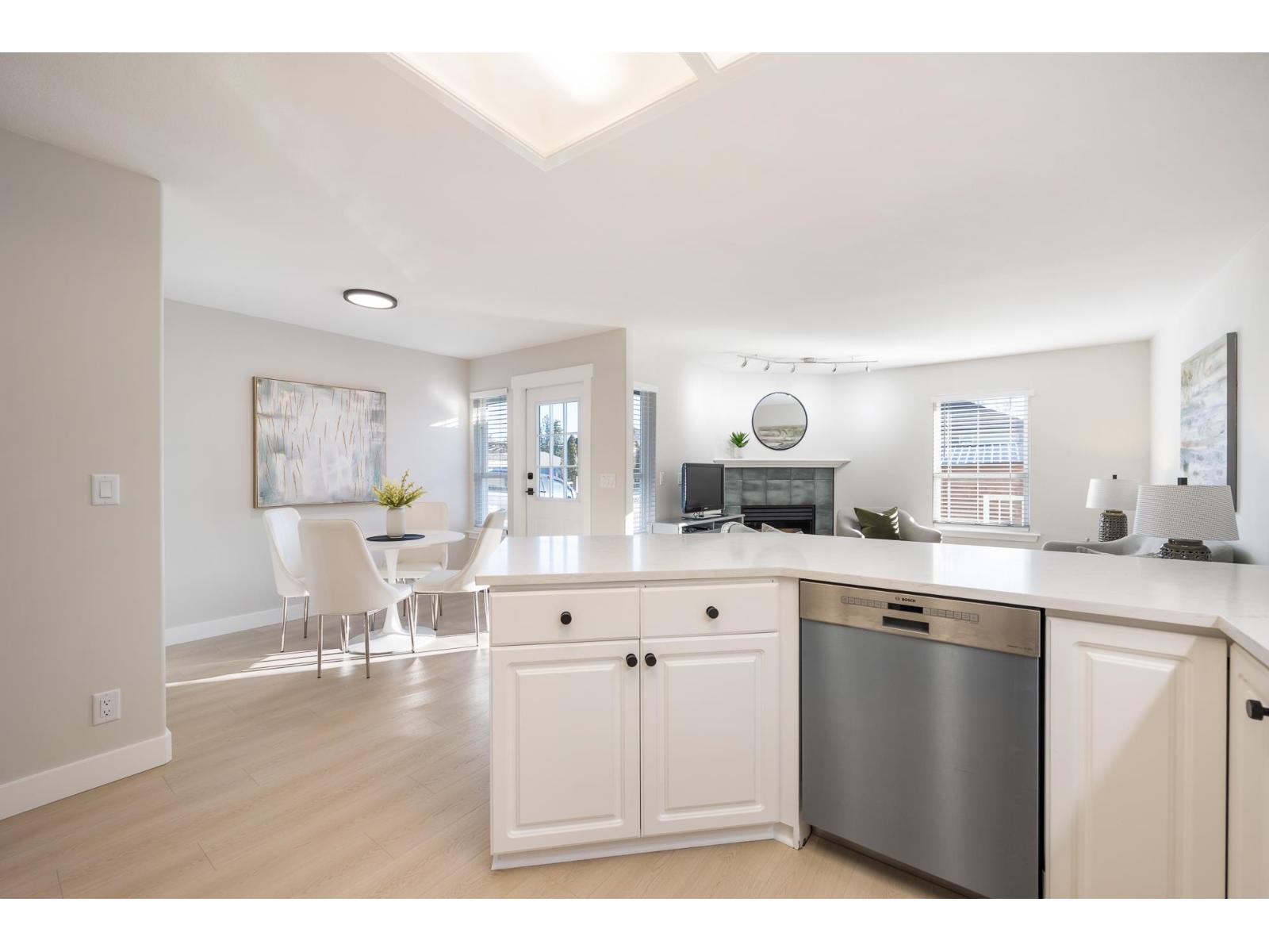 A kitchen with white cabinets and a stainless steel dishwasher.