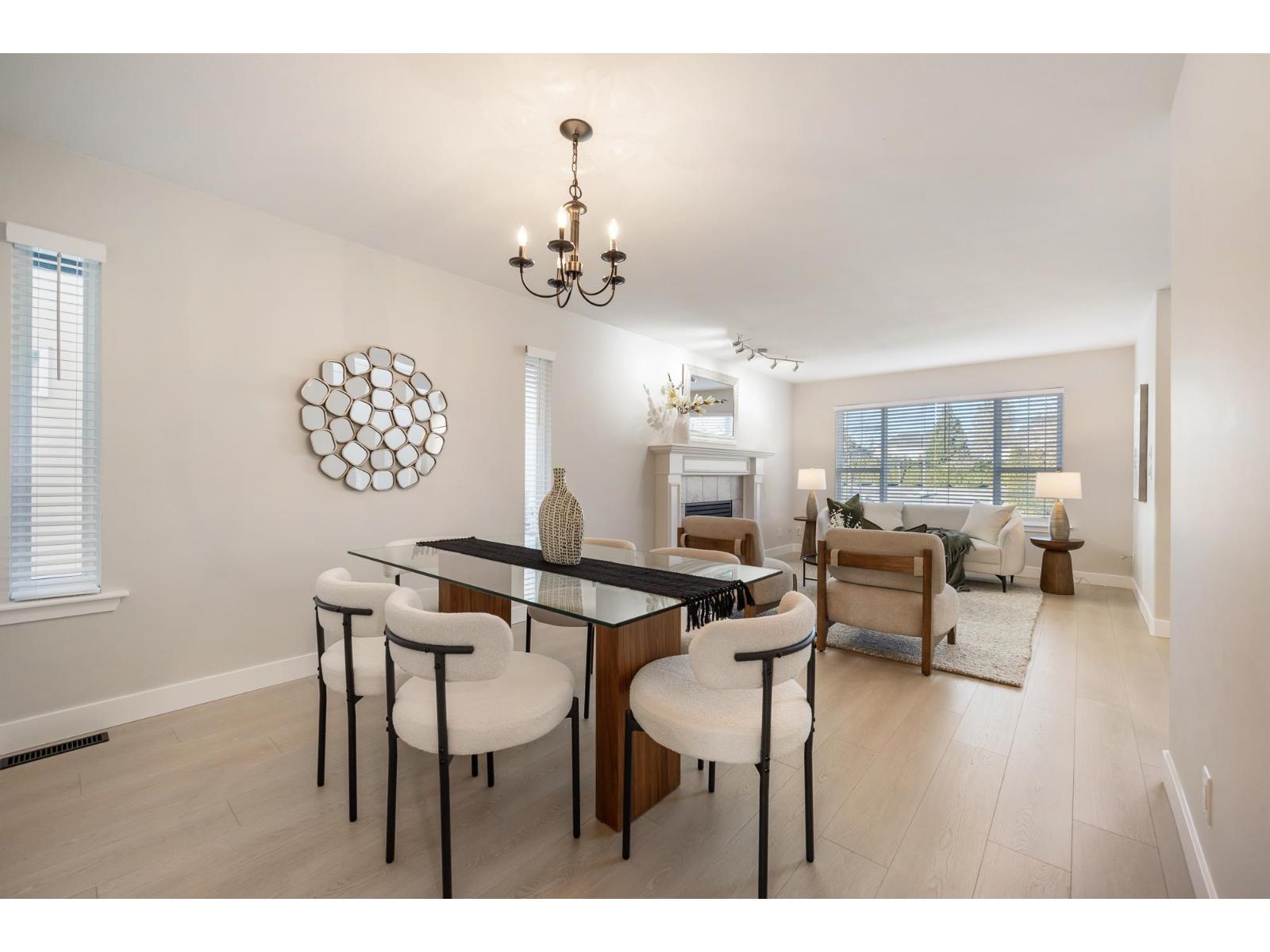 A dining room with a black table and white chairs.
