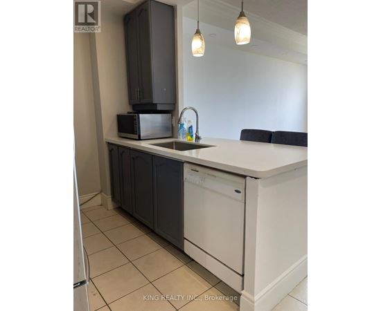 A kitchen with a white counter top and black cabinets.