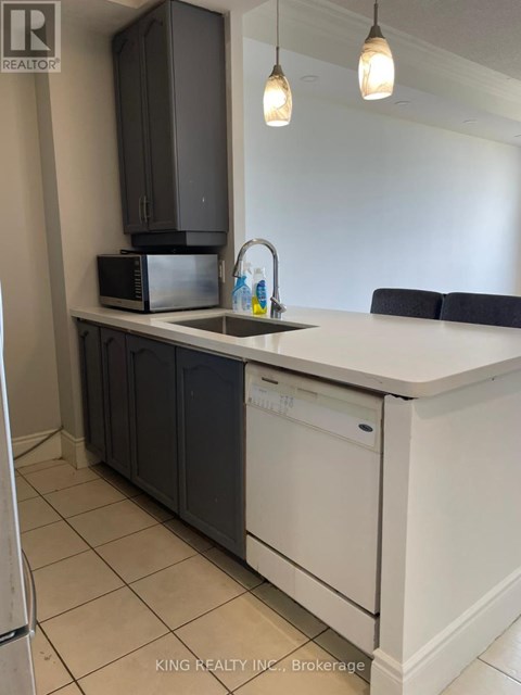 A kitchen with a white counter top and black cabinets.