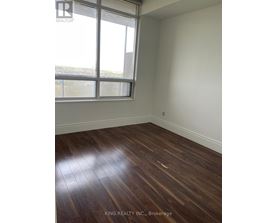 A room with a window and wooden flooring.