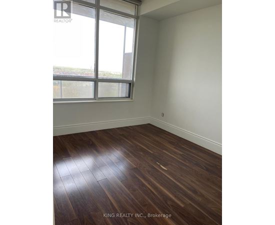 A room with a window and wooden flooring.
