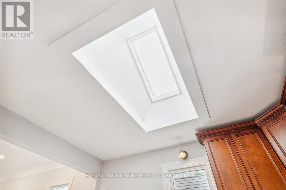 A white ceiling with a light fixture and a wooden cabinet.