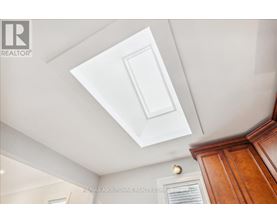 A white ceiling with a light fixture and a wooden cabinet.