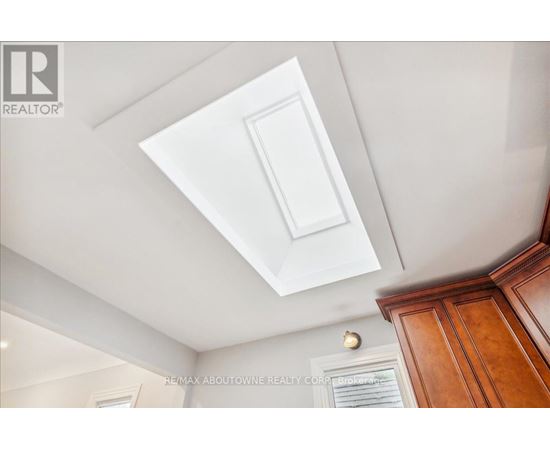 A white ceiling with a light fixture and a wooden cabinet.