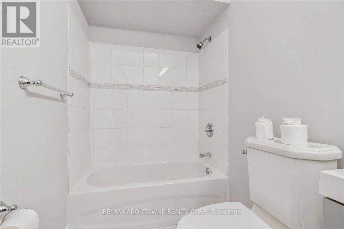 A white bathroom with a tub, toilet and sink.