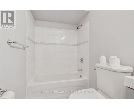 A white bathroom with a tub, toilet and sink.