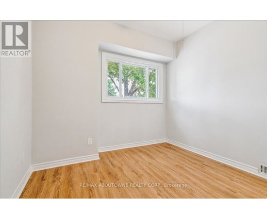 A room with a window showing trees outside.