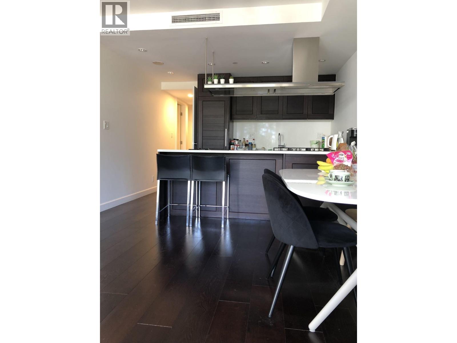 A modern kitchen with a dining table and chairs.