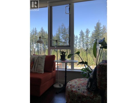 A living room with a red couch and a large window.