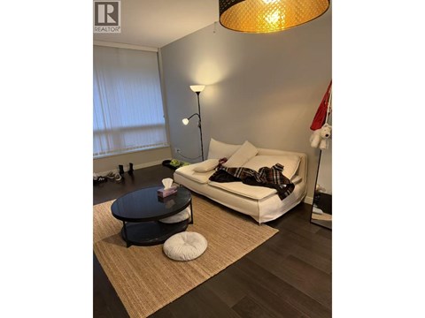 A living room with a white couch and a round table.